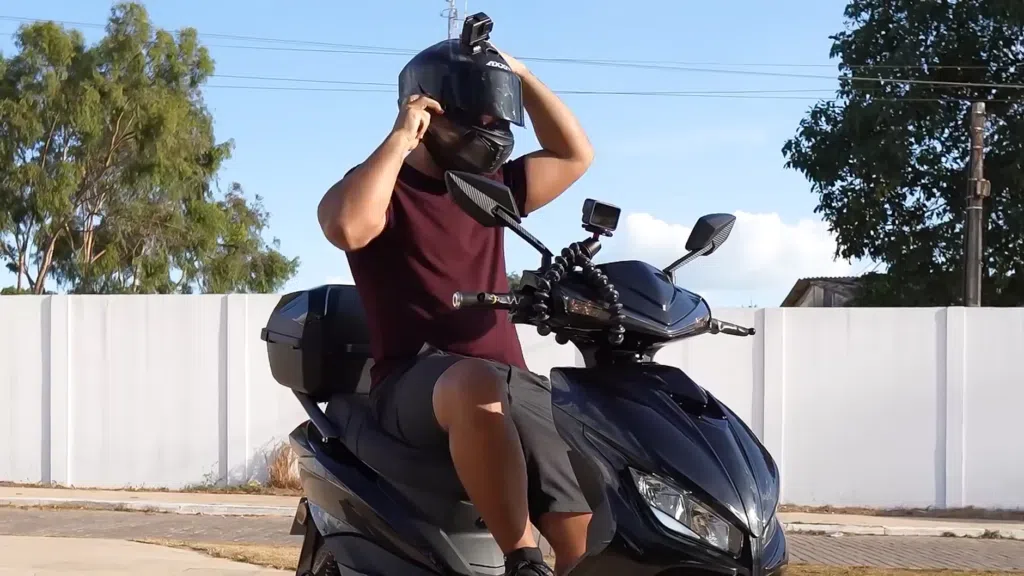 Svart motorsykkelhjelm og ål i gaten, som gjør seg klar til en scootertur.