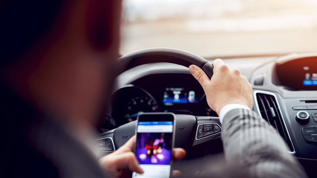 Dirigente usando smartphone no carro, tecnologia e segurança ao dirigir, notícias de tecnologia, showmetech.