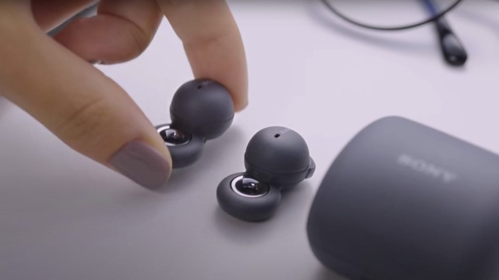 Fones de ouvido bluetooth pretos com estojo de carregamento para tecnologia portátil.
