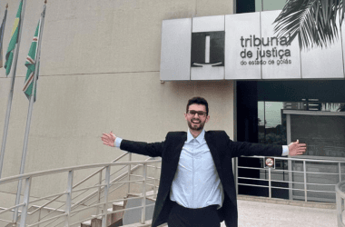 Homem feliz na frente do tribunal de justiça de goiás, celebrando vitória ou conquista.