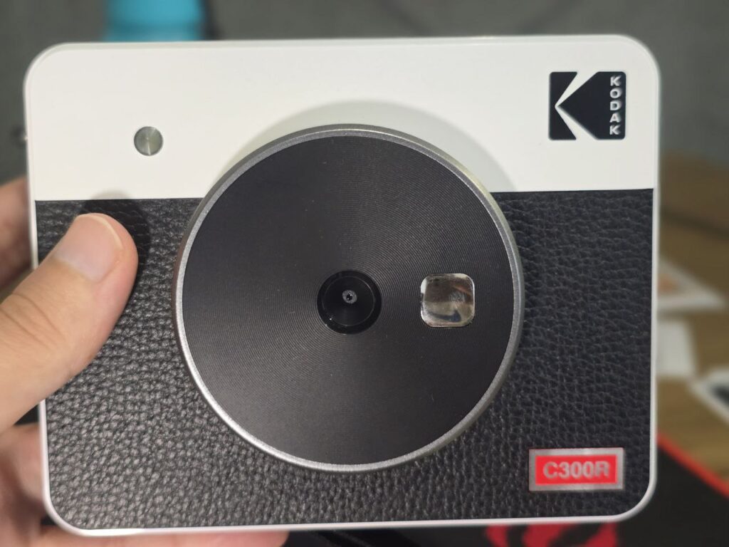 Imagem da kodak mini shot com foco na sua lente e parte frontal