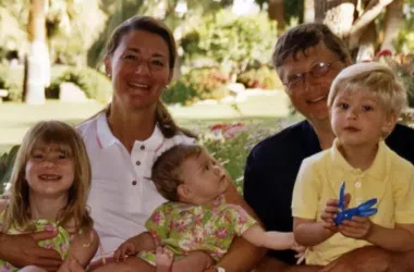 Família feliz ao ar livre, crianças e adultos sorrindo em parque com árvores.