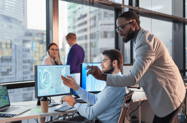 Executivos olhando para telas de computador com inteligência artificial