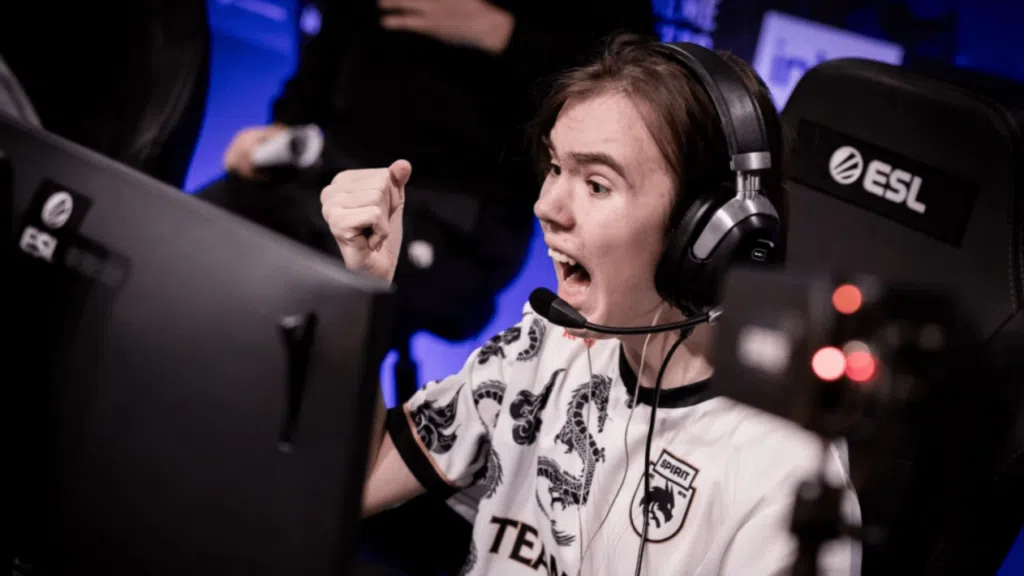 1. Jovem gamer comemorando vitória durante competição de esports com headset e monitor.