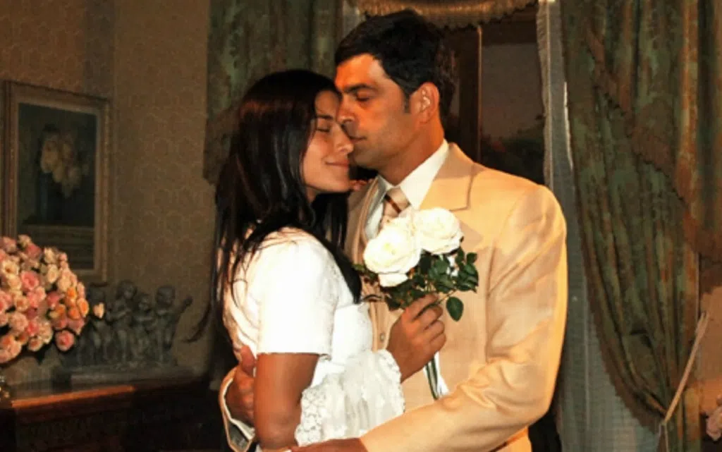 Cinta romantis, adegan pernikahan dengan pasangan yang bertukar bunga dalam suasana yang nyaman.