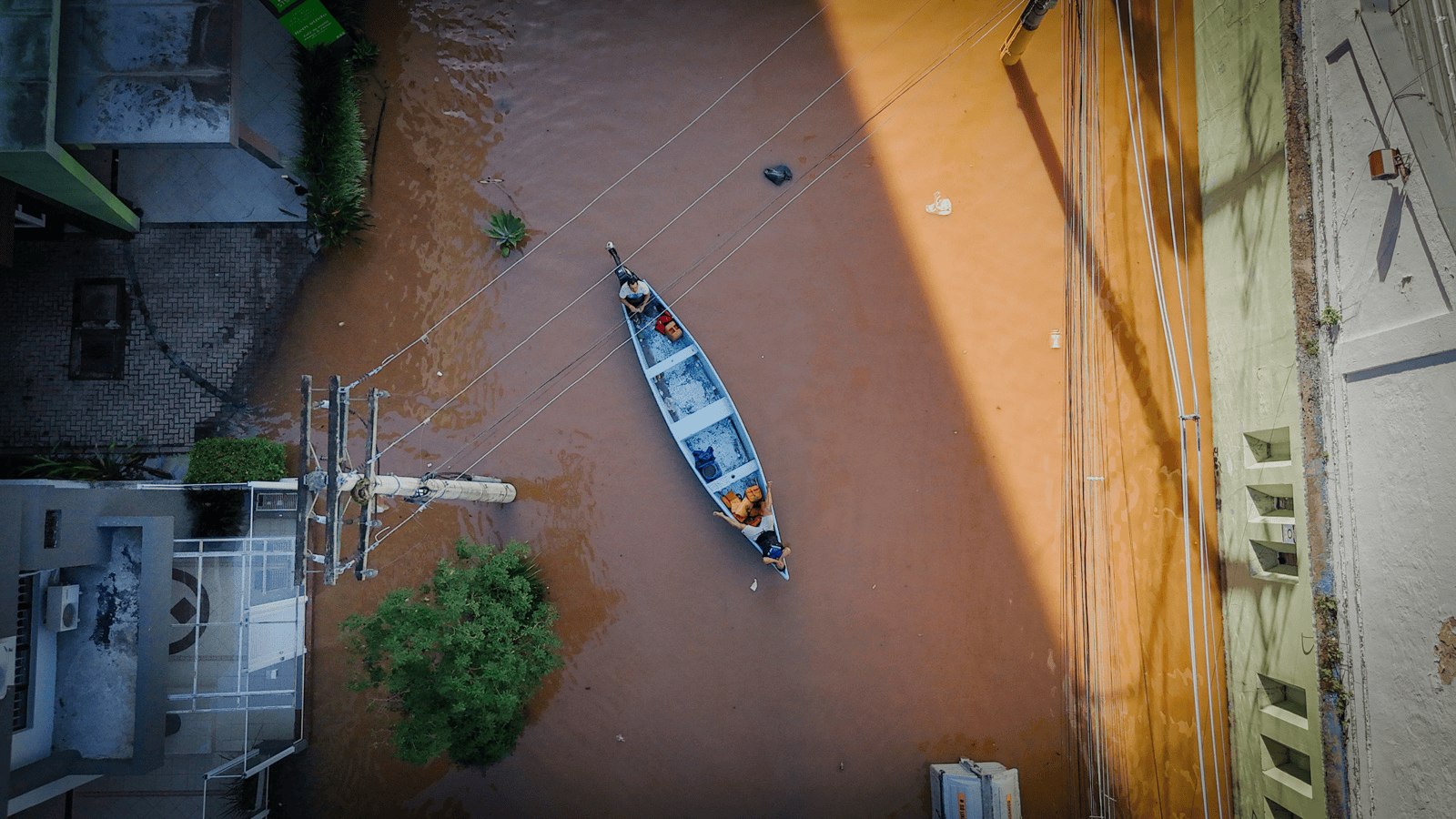 Bacia de alagamento com barco navegando, força da chuva causa enchente urbanas, situação de emergência.