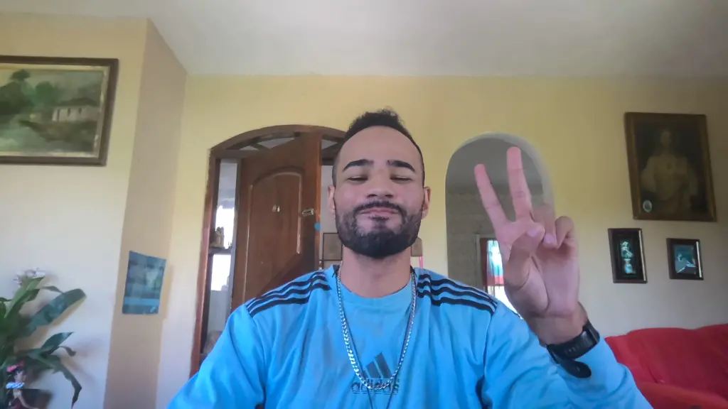 Review: galaxy book4 ultra tem alto desempenho com ia, sem deixar elegância de lado Foto de homem com cabelos pretos e de pele morena, sorrindo e fazendo gesto da paz, tirada pela câmera do galaxy book4 ultra