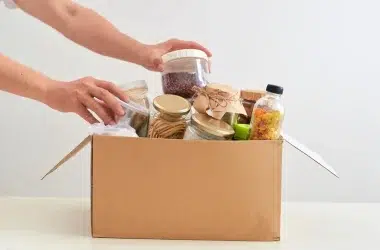Caixa de papelao recebendo alimentos para doação