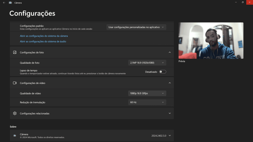 Imagem de configurações de câmera e vídeo no windows com captura de um homem usando fones de ouvido, cenário interno, site showmetech.