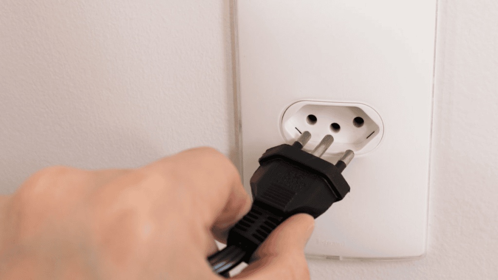 Tomada de tomada elétrica sendo plugada por uma pessoa, energia, eletricidade, energia elétrica, showmetech.