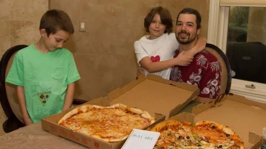Un momento delizioso con una pizza fatta in casa e una famiglia sorridente durante una cena intima.