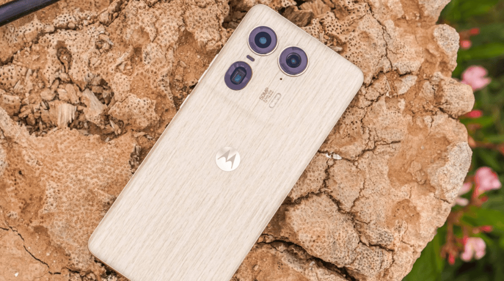 Smartphone motorola com câmera tripla e acabamento colorido em ambiente ao ar livre.