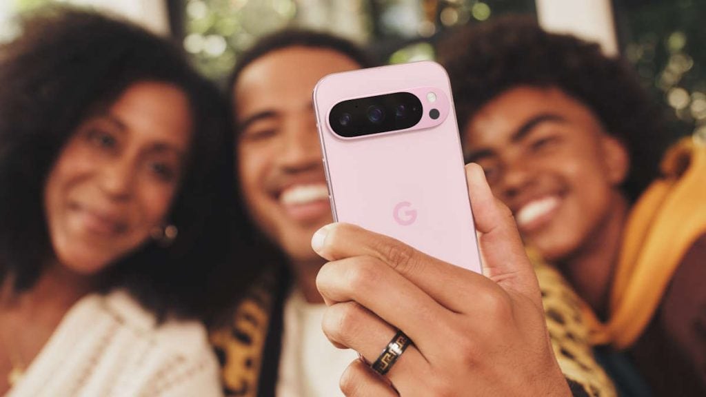 Foto de pessoas sorridentes tirando selfie com smartphone google pixel, foco na câmera.