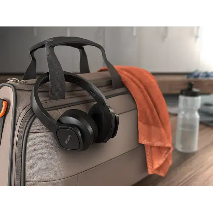 Fones de ouvido philips no laptop com maleta e toalha laranja, estilo de vida digital e tecnologia.