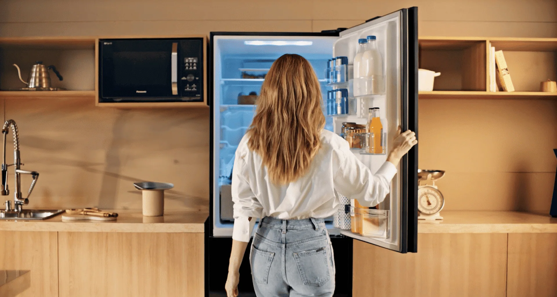 Réfrigérateur intelligent à portes ouvertes dans une cuisine moderne et minimaliste.