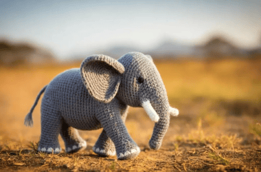 Elefante de tricô em campo de terra, artesanato criativo e decorativo, presente artesanal, brinquedo de crochê fofo.