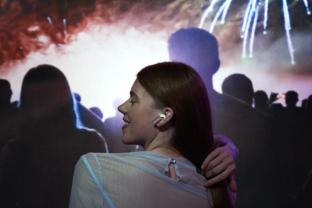 Welke moet je kiezen? Galaxy Buds3 of Galaxy Buds3 Pro? Vrouw geniet met Galaxy Buds3 Pro op evenement