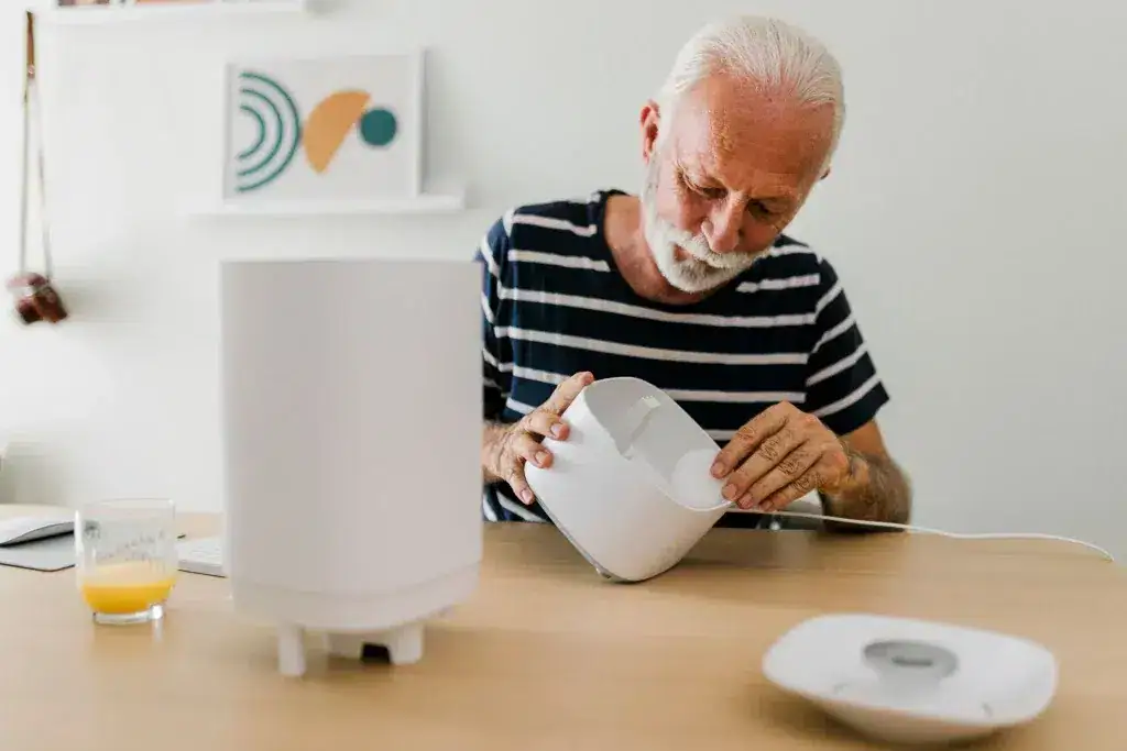 今買うべき最高の加湿器10選 加湿器のフィルターを交換する老人