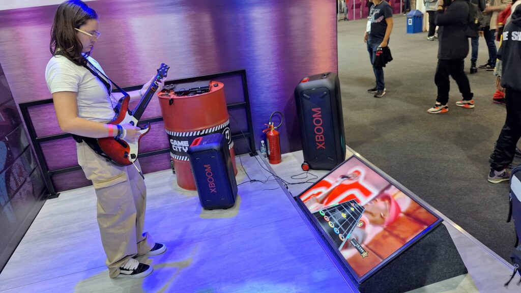 Guitar hero sendo usado como ativação no estande da lg para testar as caixas de som