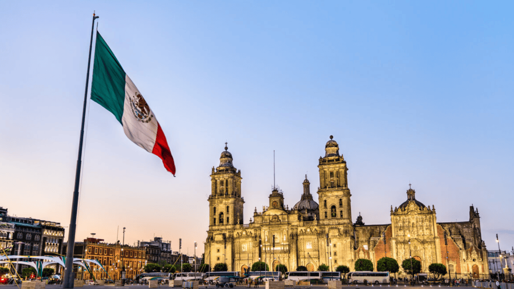 Bandeira do méxico em frente à catedral histórica na cidade mexico city, símbolo nacional e cultural do país.