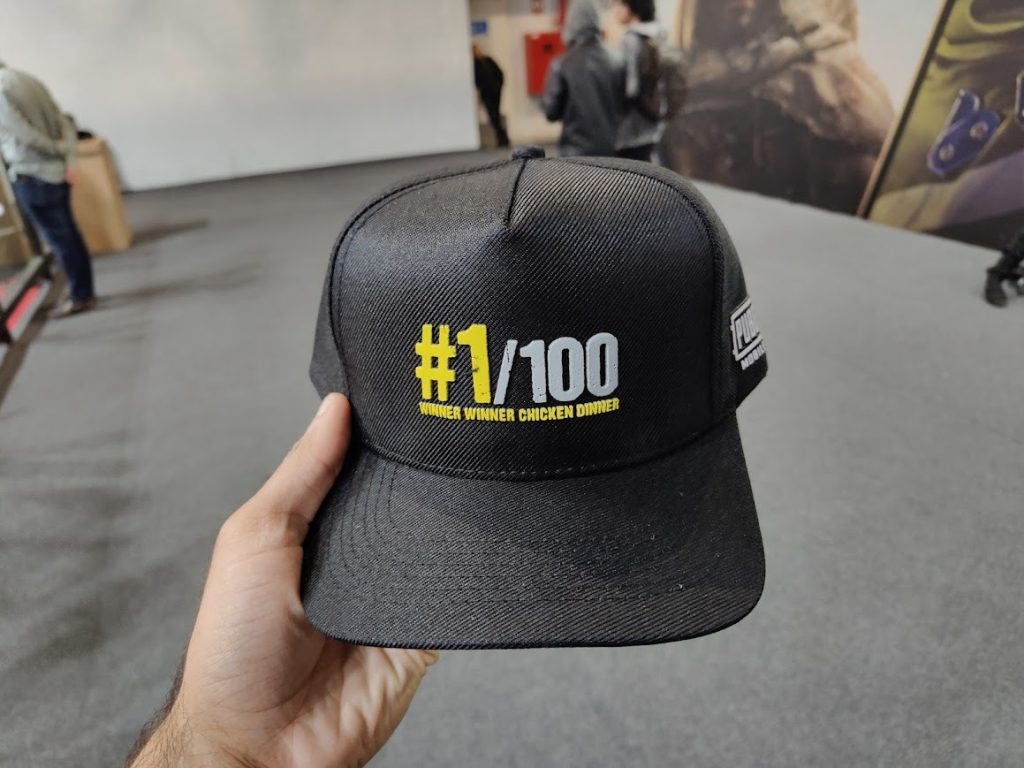 Camisa com estampa "#1/100 winner winner chicken dinner" em evento de tecnologia.