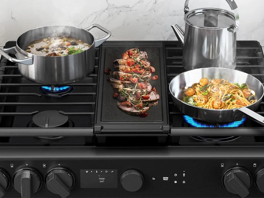 Chaleira elétrica,frigideira e panela de aço inoxidável em fogão a gás com comida deliciosa.