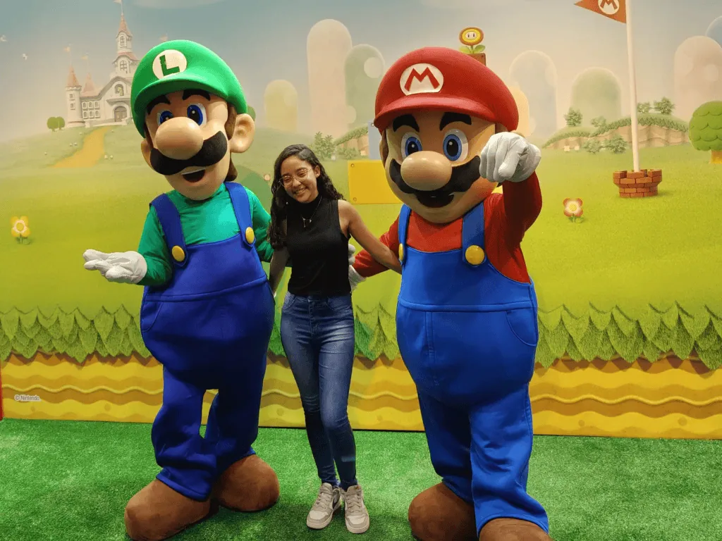 Guia de brindes da bgs 2024: ganhe os melhores! Menina tirando foto com mario e luigi na bgs 2024