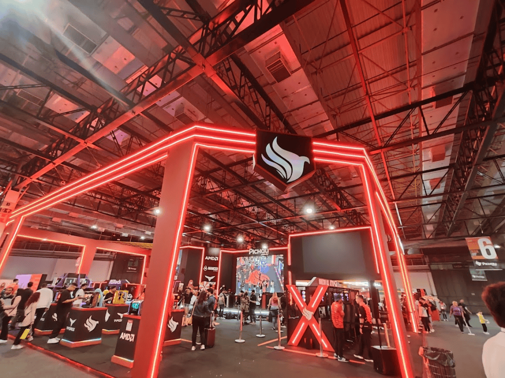 1. Estação de tecnologia no evento showmetech com iluminação em led vermelha e marcas de grandes empresas.