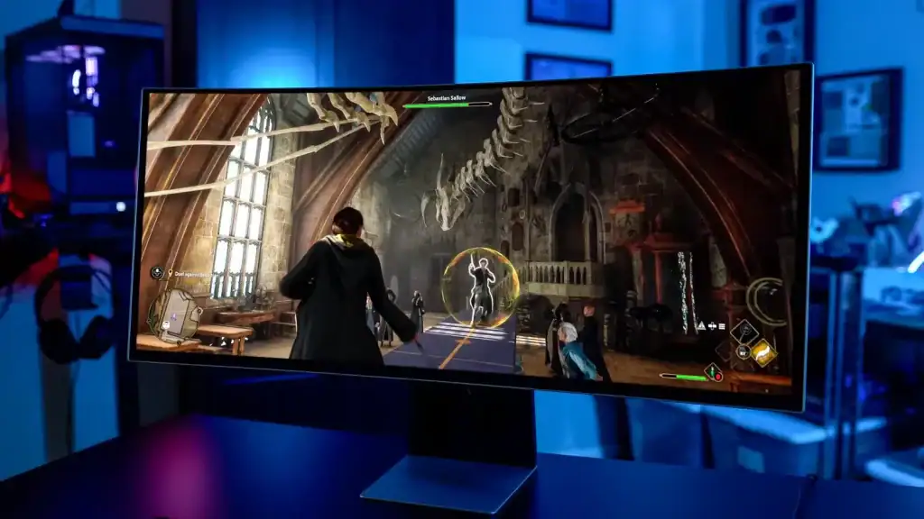 Monitor gamer com tela curva exibindo jogo de ação em ambiente de data center ou sala de jogos.