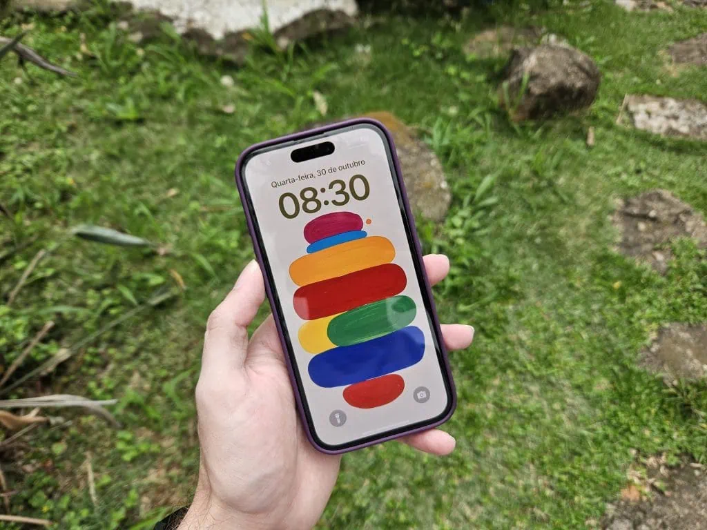 Anmeldelse: iPhone 16, hjemmehørende i en tidsalder av kunstig intelligens 1. Smarttelefon med fargeskjerm som viser dato og klokkeslett, midt i naturen.