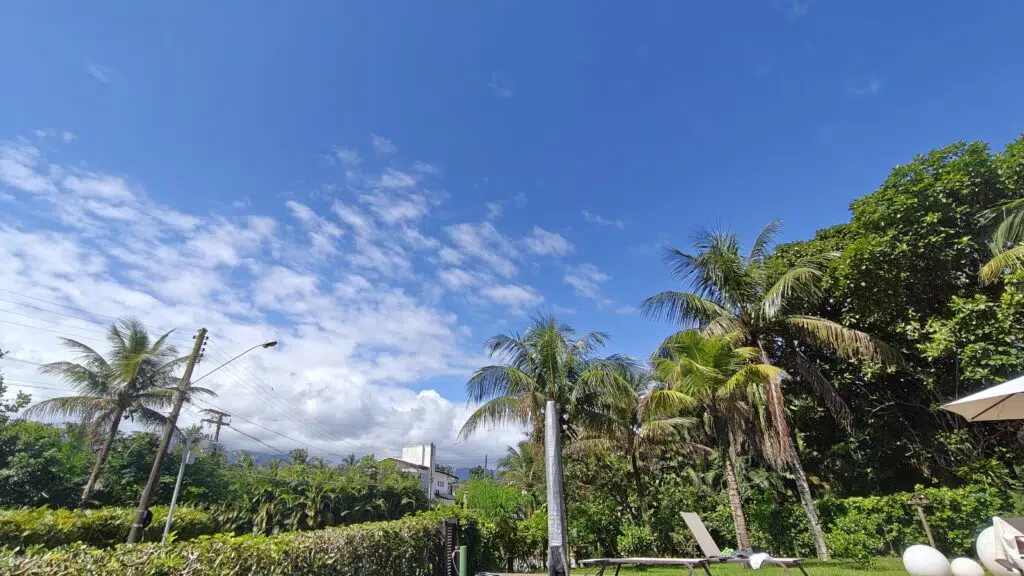 Review: realme gt 7 pro combina ótimo desempenho e fotos incríveis Céu azul, coqueiros e algumas nuvens em bairro no litoral