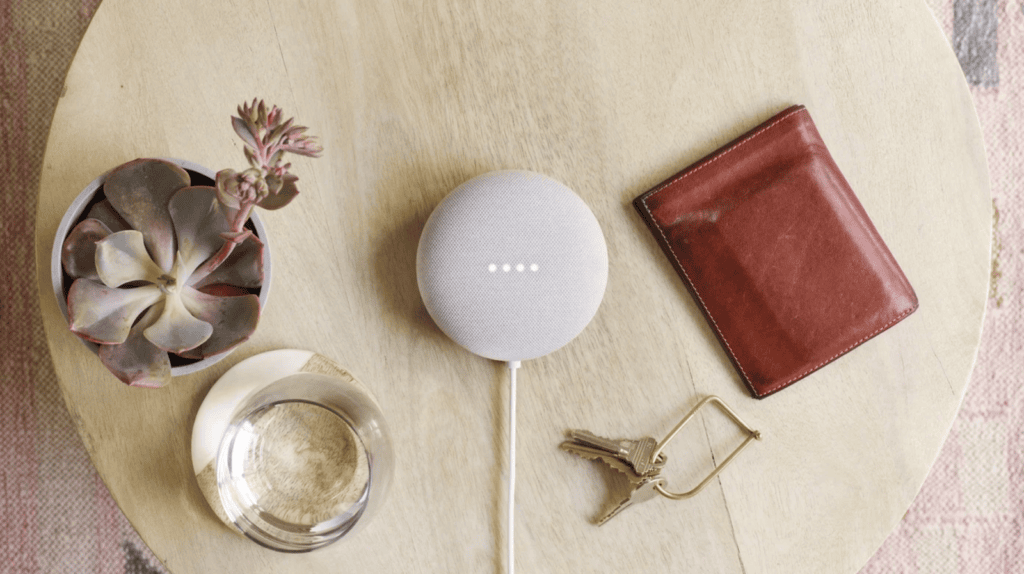 Veja os melhores produtos para a casa conectada (2025) Esses itens com assistente de voz, como google nest, aparecem em mesa com celular, chave e objetos pessoais.