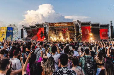 Show de música ao vivo em festival com grande público e palco iluminado, evento cultural e artístico.