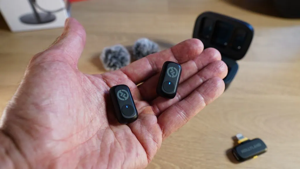 Review: hollyland lark a1, o kit de microfones sem fio com melhor custo-benefício de 2025 Uma mão segurando dois microfones
