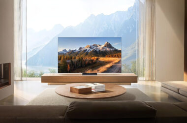 Smart tv exibindo paisagem montanhosa com janela de vidro ao fundo.