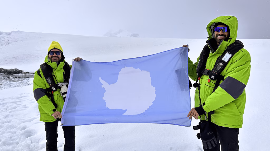 Aventuras na antartica: uma viagem de descobertas Segurando a bandeira com o mapa da antartica, o sétimo continente