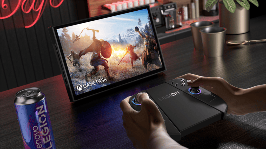 Controle de videogame lenovo legion em uso com monitor portátil e bebida energética ao fundo.