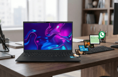 Tela de notebook com várias telas de smartphones e aplicativos de mensagens, ambiente de escritório moderno.