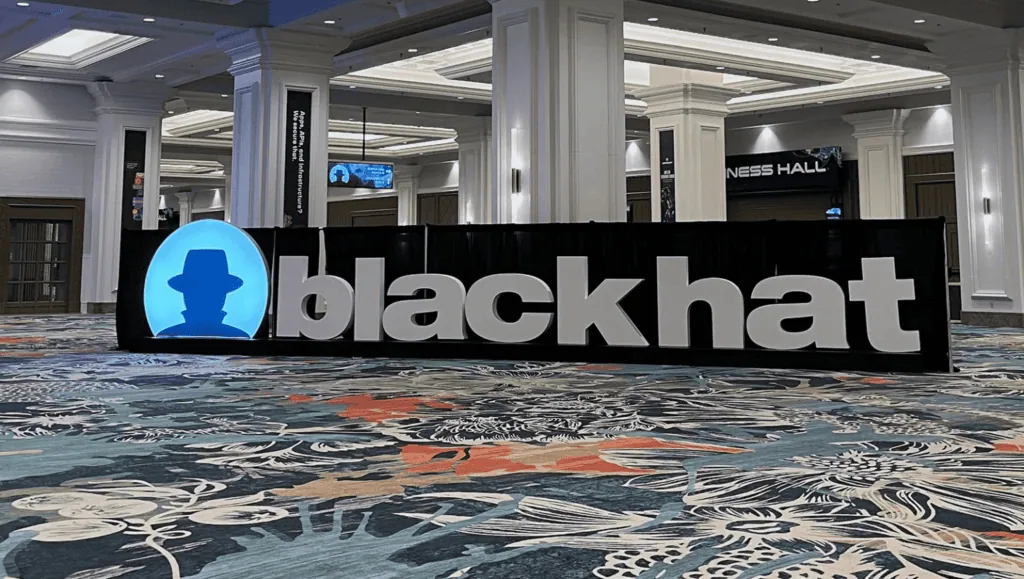 Calendário tech 2026: os principais eventos de tecnologia e inovação do ano Imagem do estande do black hat em conferência de segurança e tecnologia.