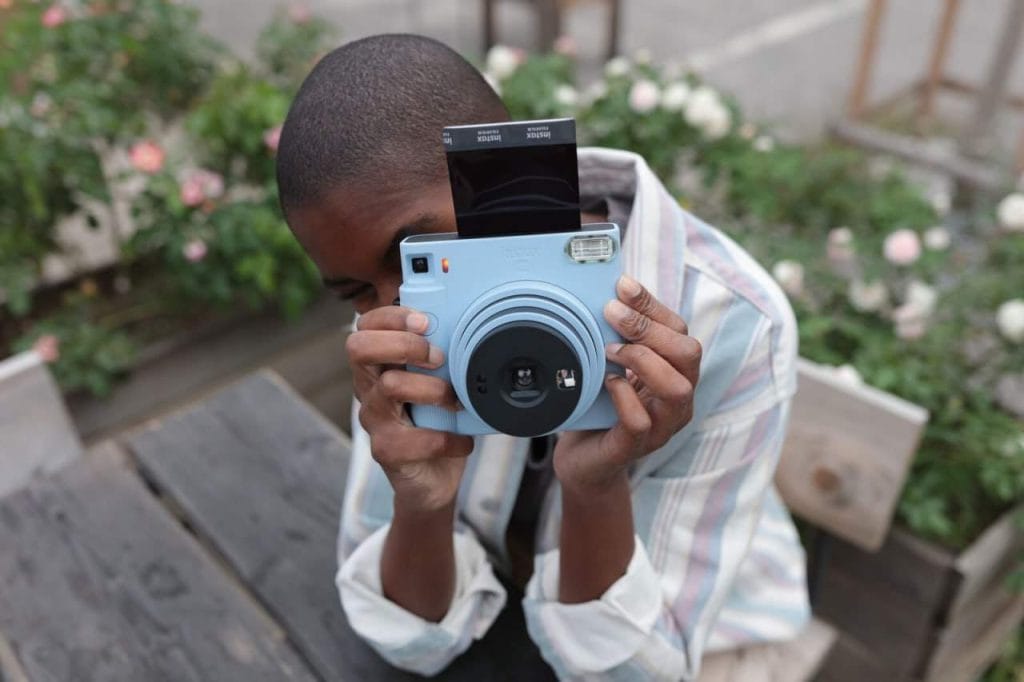 Mulher negra usando instax mini