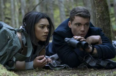 Imagem de dois jovens observando pelo binóculo na floresta.