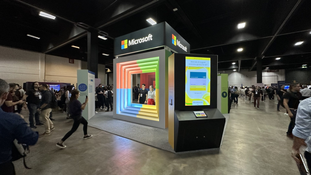 Calendário tech 2026: os principais eventos de tecnologia e inovação do ano Estande da microsoft em evento de tecnologia com visitantes e displays interativos.
