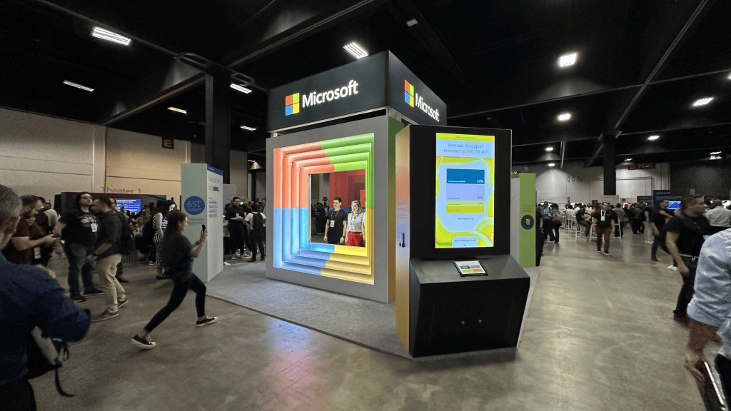 Calendário tech 2026: os principais eventos de tecnologia e inovação do ano Estande da microsoft em evento de tecnologia com visitantes e displays interativos.