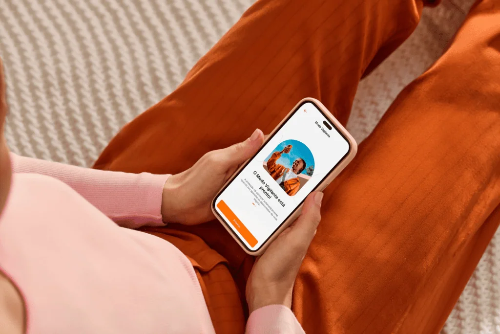 Apps de bancos: como ativar o modo de proteção por localização Pessoa usando smartphone para ativar modo de proteção por localização no app bancário.
