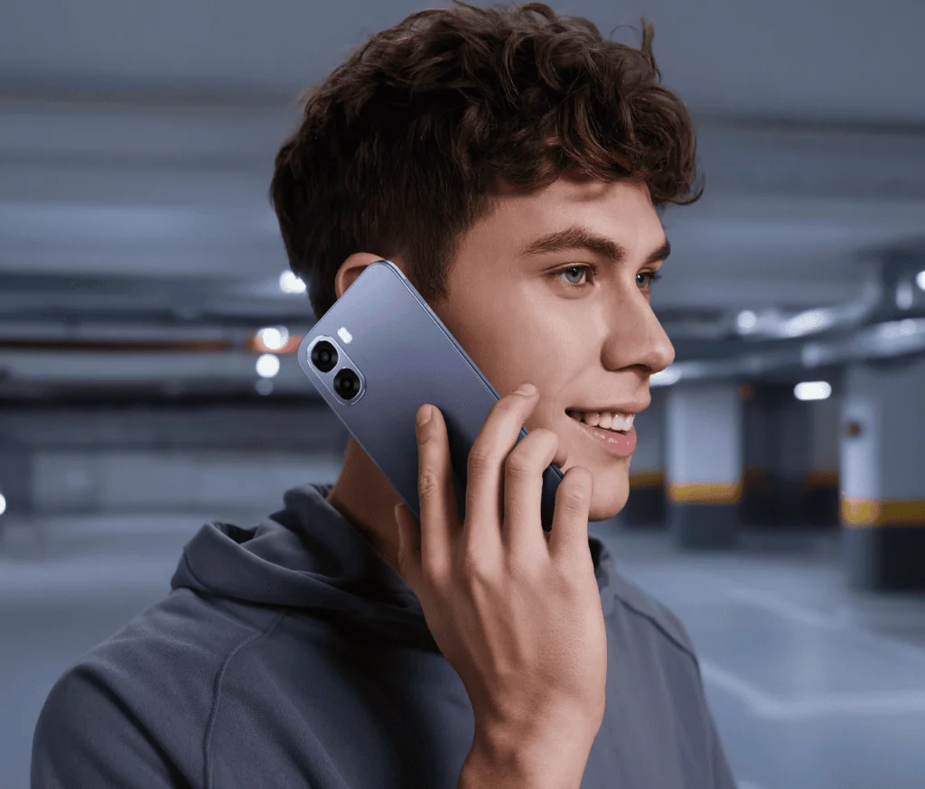 Smartphone oppo a6x tem bateria de longa duração sem abrir mão do desempenho para o dia a dia Jovem usando smartphone oppo a6x em estacionamento moderno.