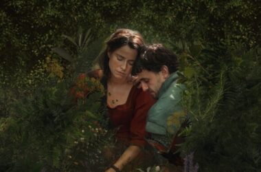 Imagem de um casal em um jardim, olhando com atenção para algo à sua frente.