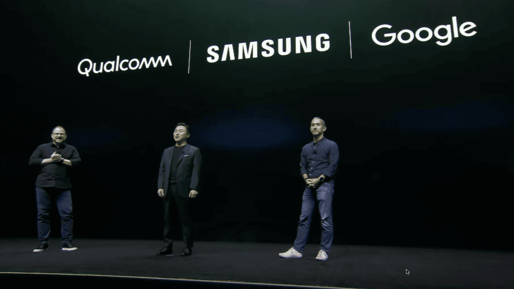 Imagem de executivos na apresentação do samsung galaxy glasses com logos da qualcomm, samsung e goog.
