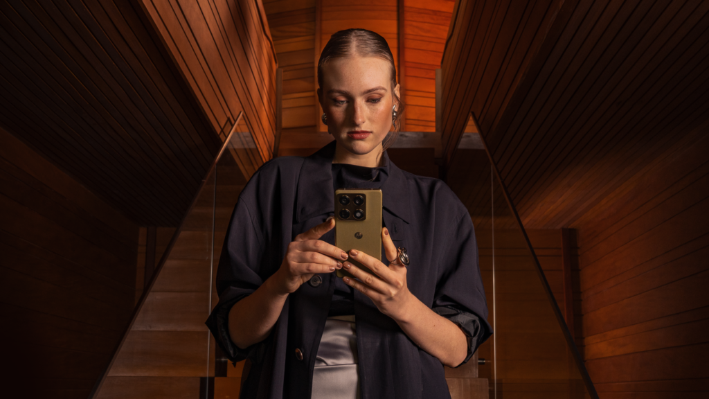 Mulher segurando o smartphone motorola signature em ambiente elegante.