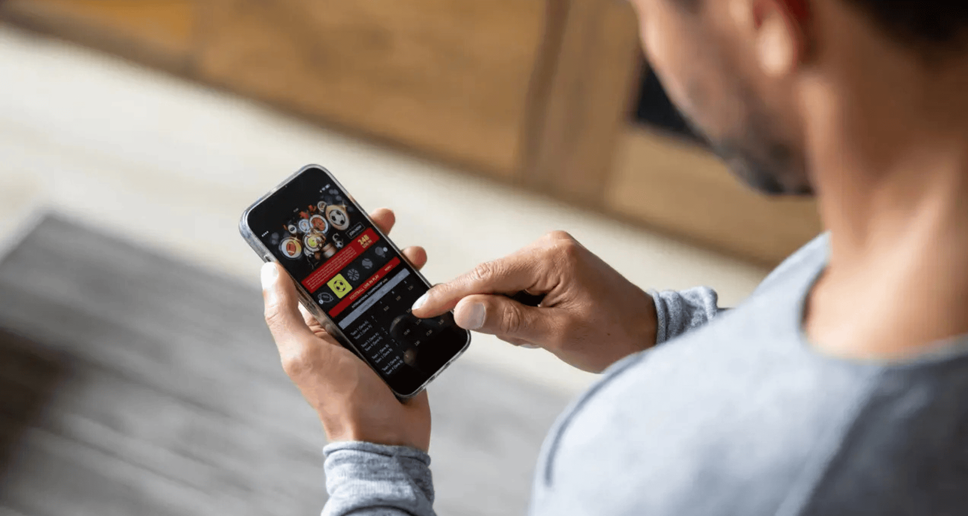 Homem com vício em apostas usando celular