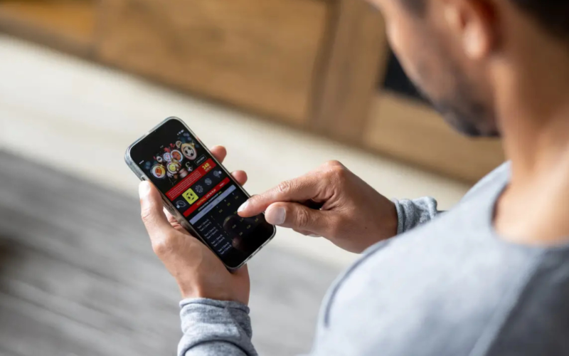 Homem com vício em apostas usando celular